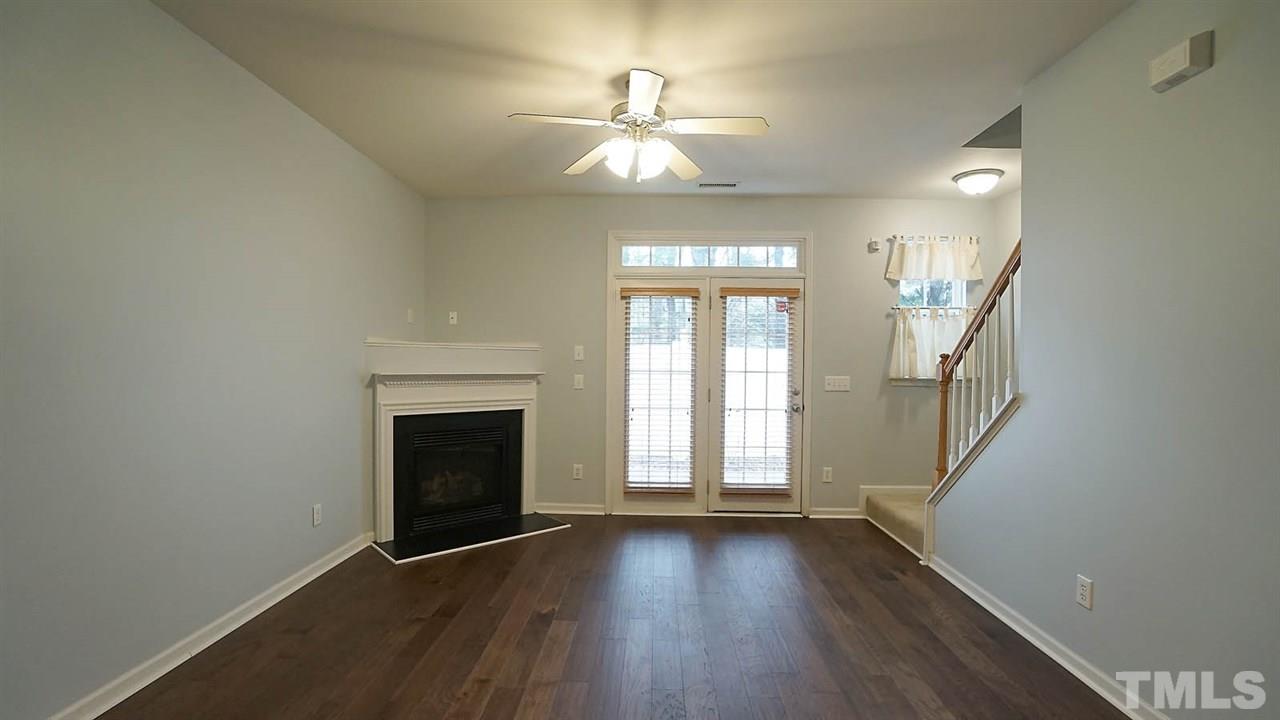 8311 Martello Lane Raleigh, NC 27613 - Photo 10 of 30 wooden floor in an empty room with a fireplace