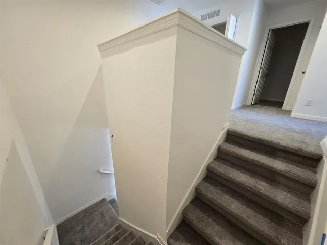 an entryway with white walls and tiles