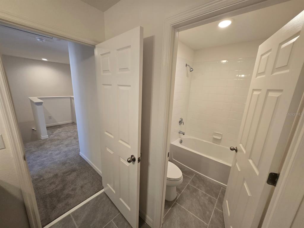 4827 Noble Cypress Street Kissimmee, FL 34746 - Photo 20 of 29 a bathroom with a tub and a shower