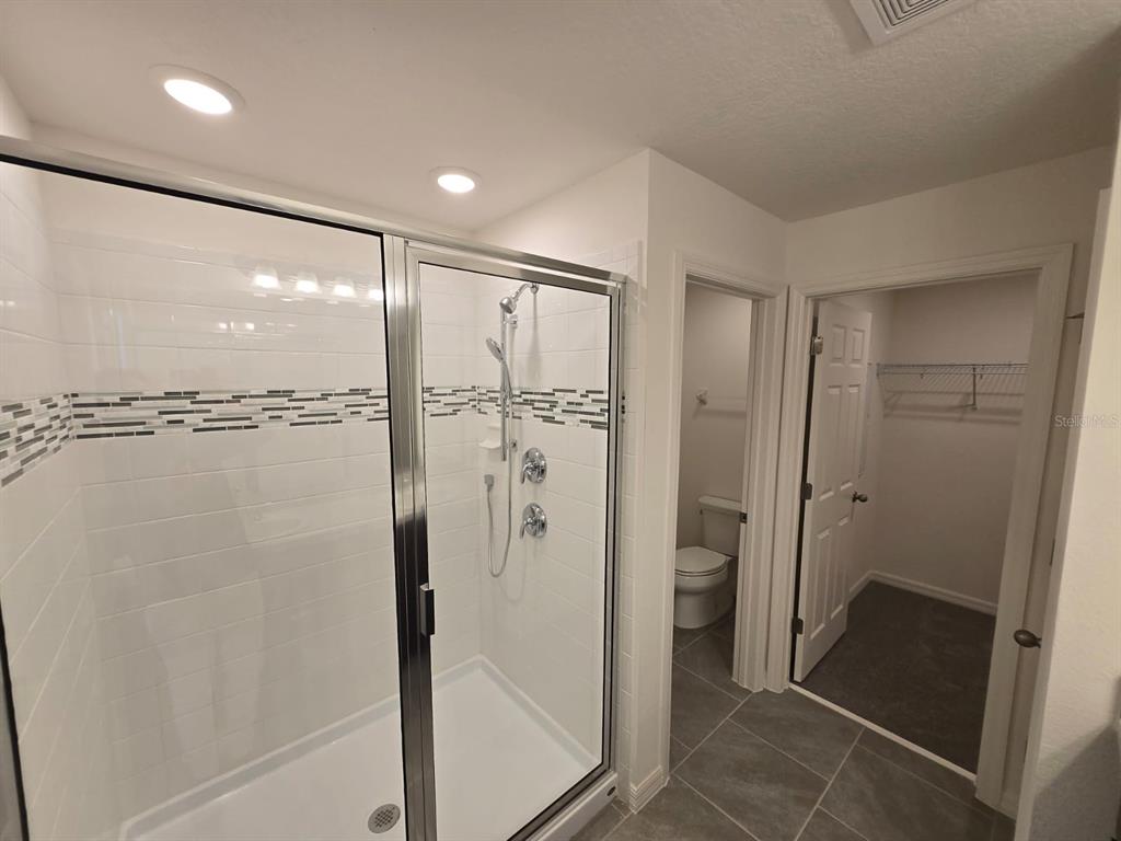 4827 Noble Cypress Street Kissimmee, FL 34746 - Photo 27 of 29 a bathroom with a glass shower door and a sink