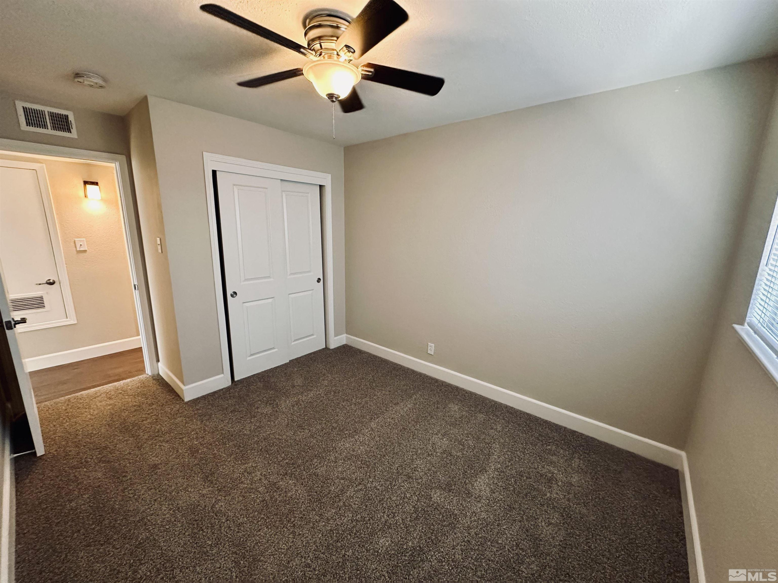 1945 Gridley Avenue Reno, NV 89503 - Photo 15 of 27 an empty room with a ceiling fan and carpet