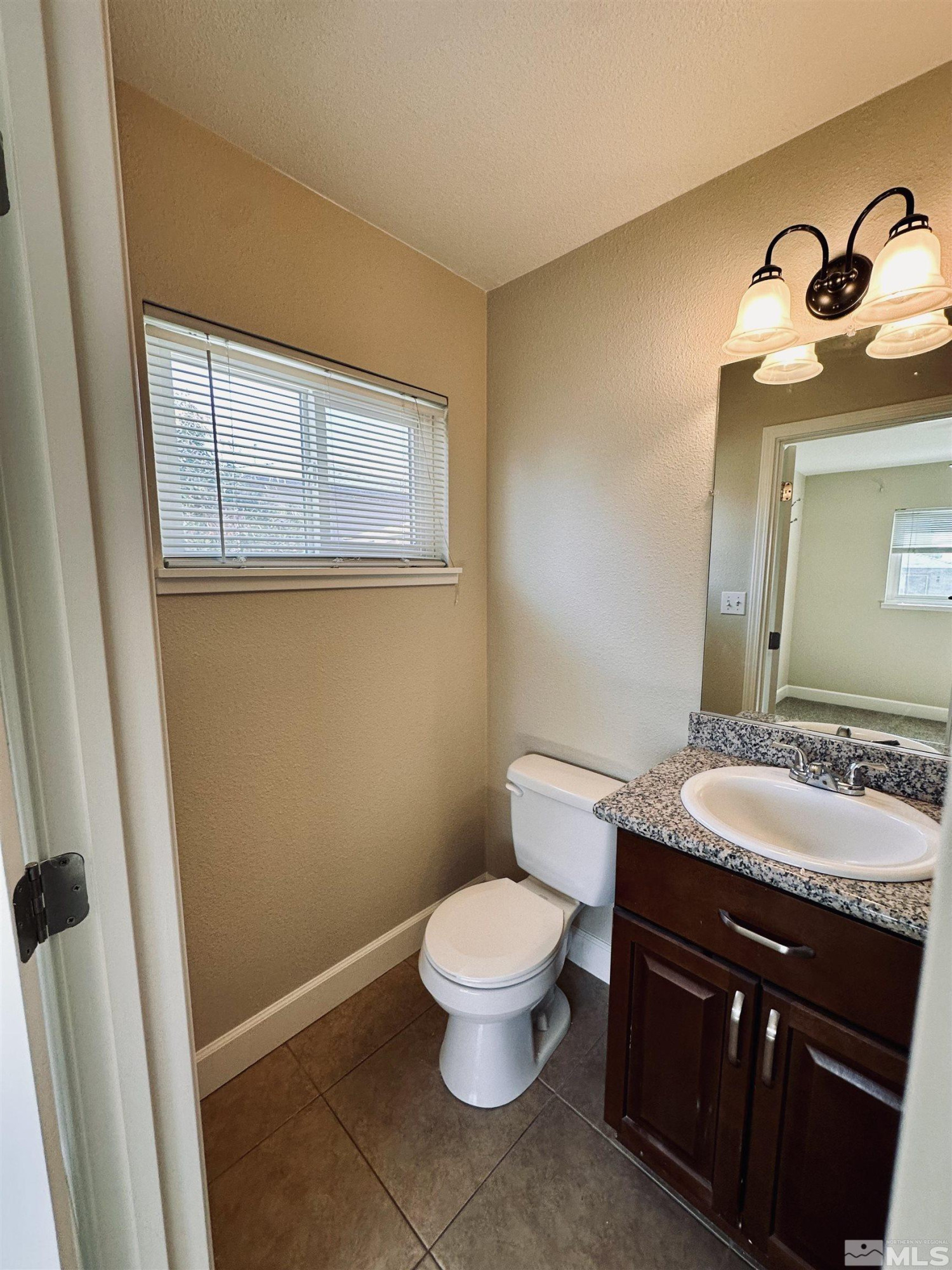 1945 Gridley Avenue Reno, NV 89503 - Photo 21 of 27 a bathroom with a granite countertop sink toilet a mirror and a window