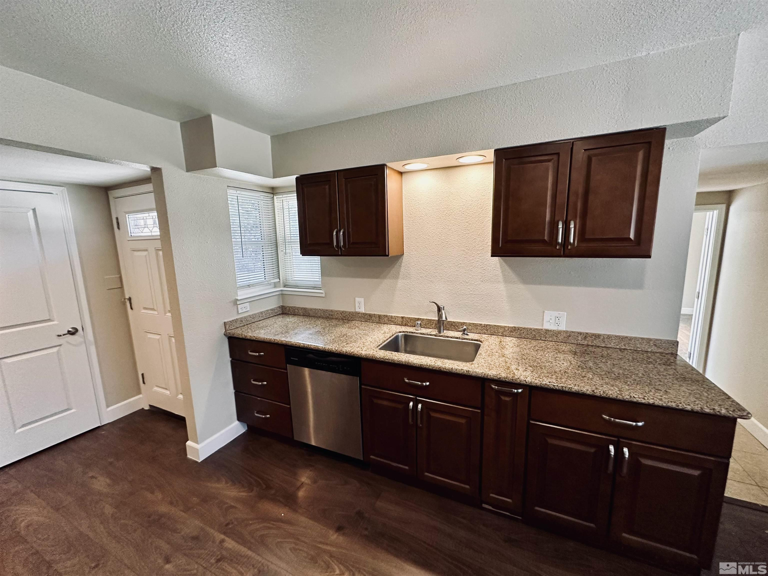 1945 Gridley Avenue Reno, NV 89503 - Photo 26 of 27 a kitchen with stainless steel appliances granite countertop a sink and a microwave