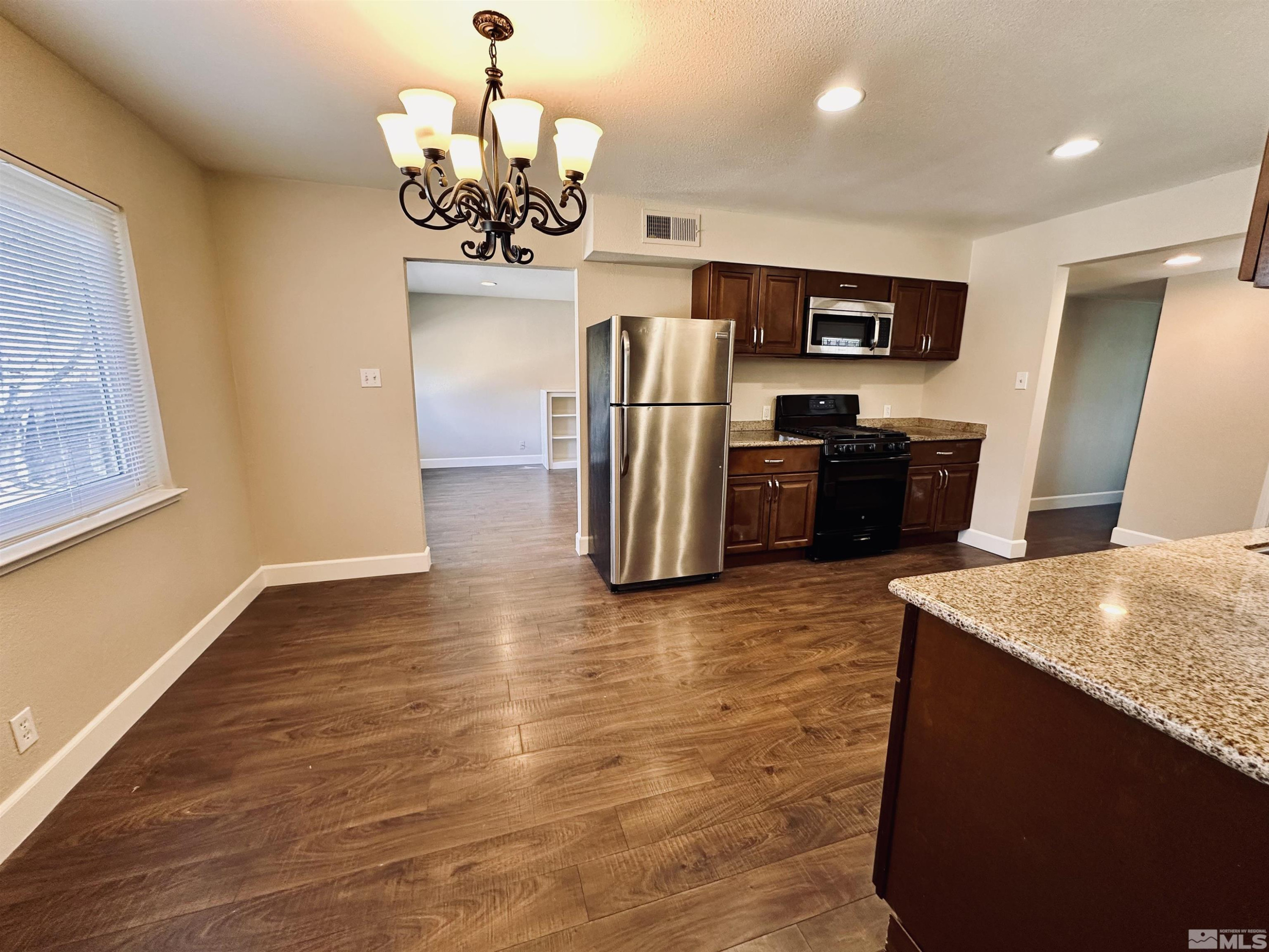 1945 Gridley Avenue Reno, NV 89503 - Photo 5 of 27 a kitchen with stainless steel appliances granite countertop a refrigerator and a stove top oven