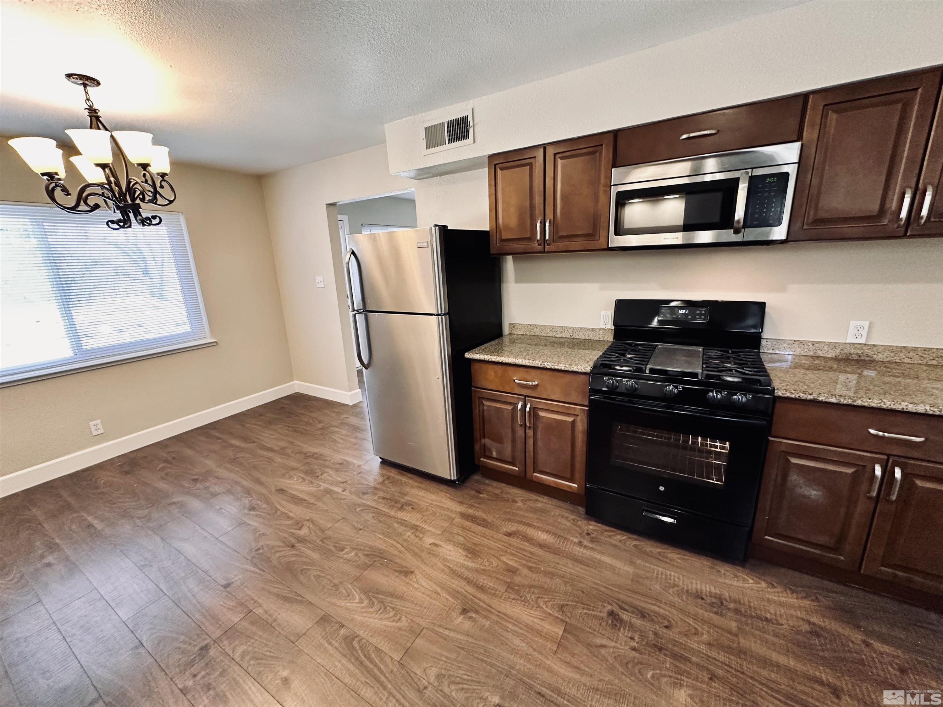 1945 Gridley Avenue Reno, NV 89503 - Photo 6 of 27 a kitchen with stainless steel appliances granite countertop a refrigerator stove and microwave