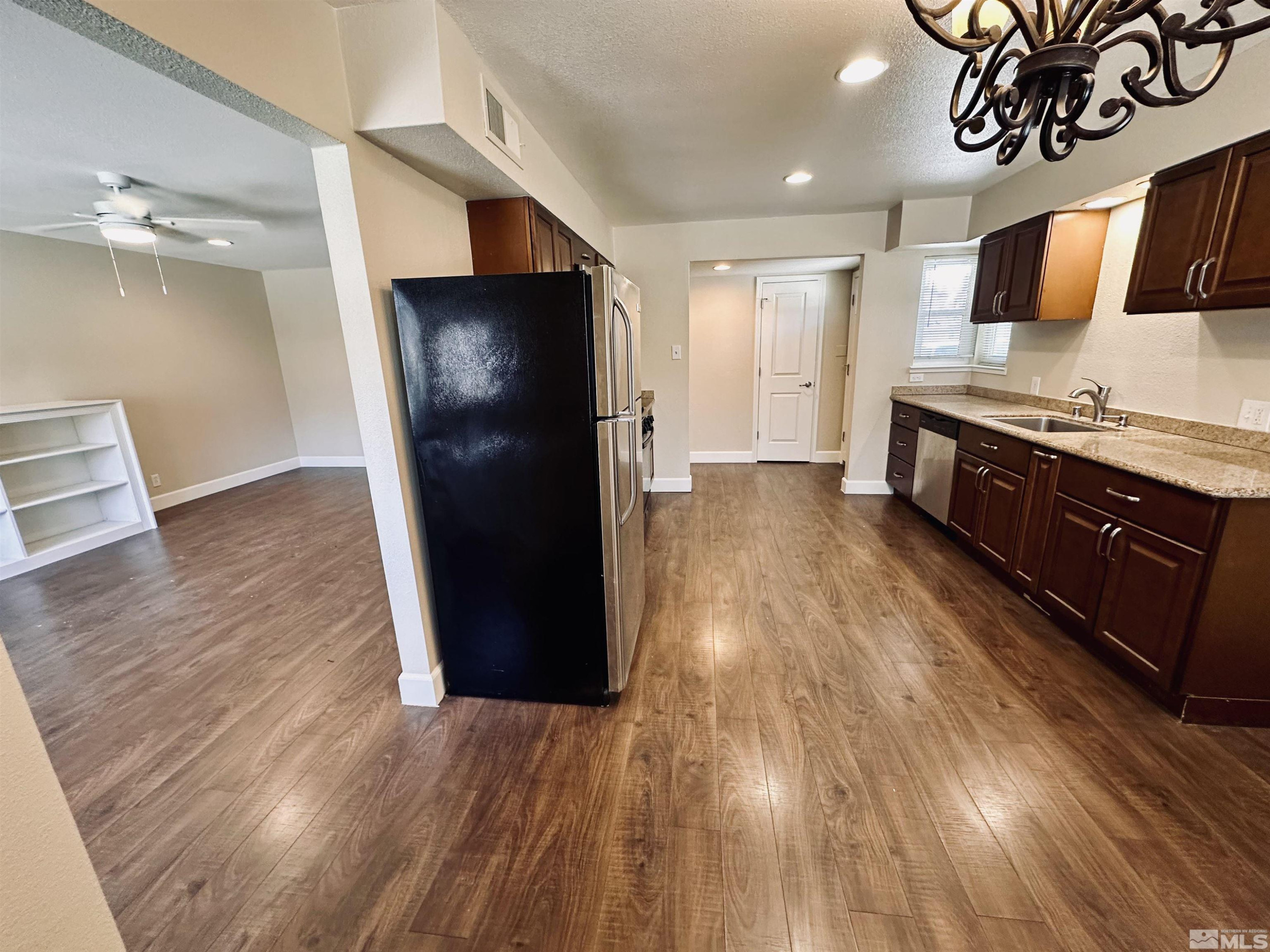 1945 Gridley Avenue Reno, NV 89503 - Photo 9 of 27 a kitchen with stainless steel appliances granite countertop a refrigerator a sink and wooden cabinets