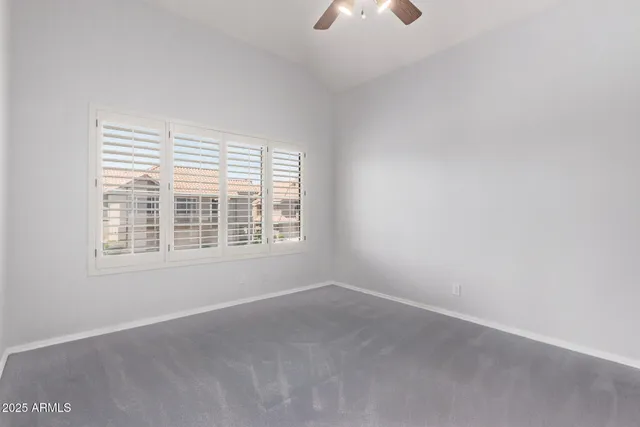 an empty room with closet and a chandelier fan