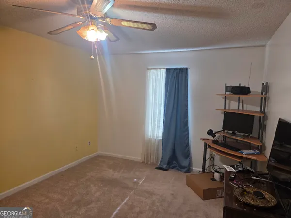 a view of a workspace with furniture and a window