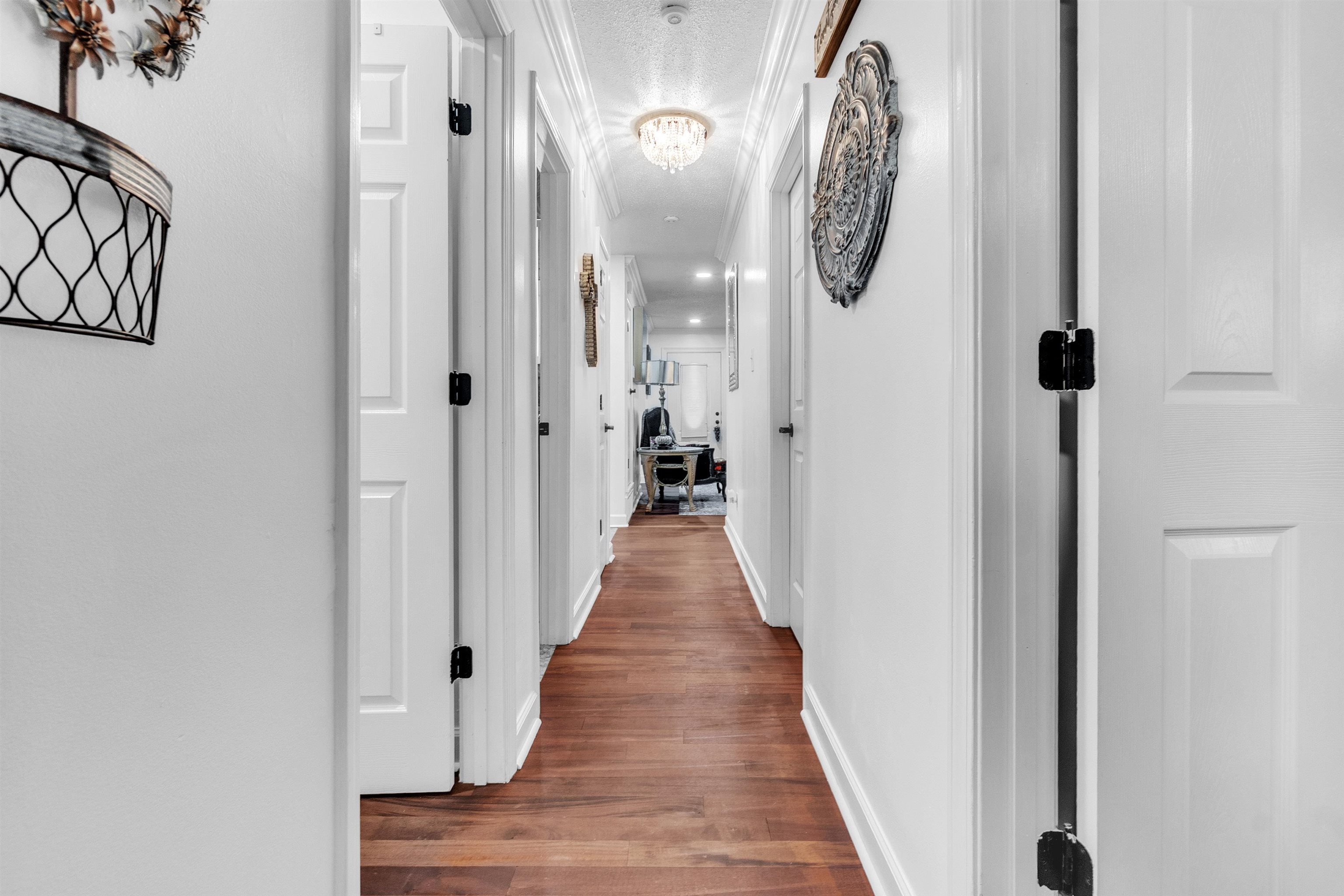 3029 Andy Road Memphis, TN 38109 - Photo 17 of 21 Hallway featuring wood finished floors, baseboards, and a chandelier