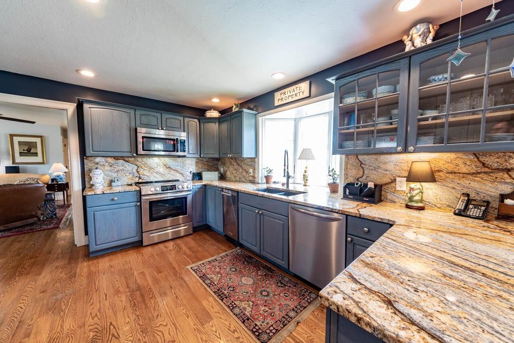 225 Levis Road Portersville, PA 16051 - Photo 4 of 24 a kitchen with stainless steel appliances granite countertop a stove top oven a sink dishwasher a dining table and chairs with wooden floor