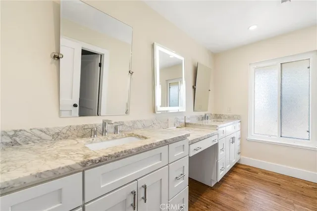 a bathroom with a granite countertop sink double and mirror