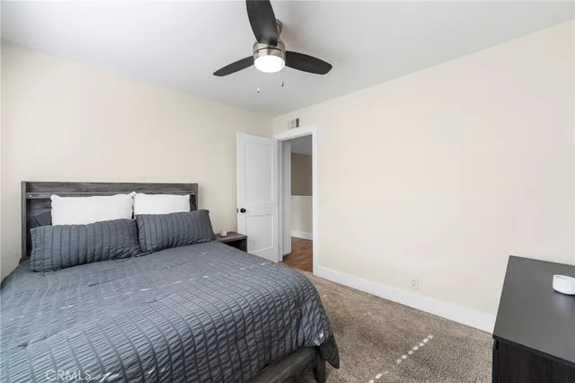 a bedroom with a bed and a ceiling fan