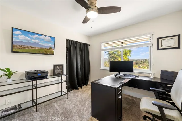 a view of a workspace with furniture and a window