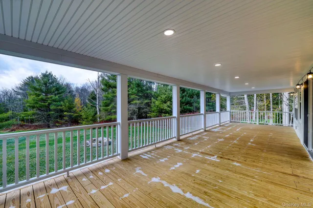 a view of an empty room with wooden floor and fence