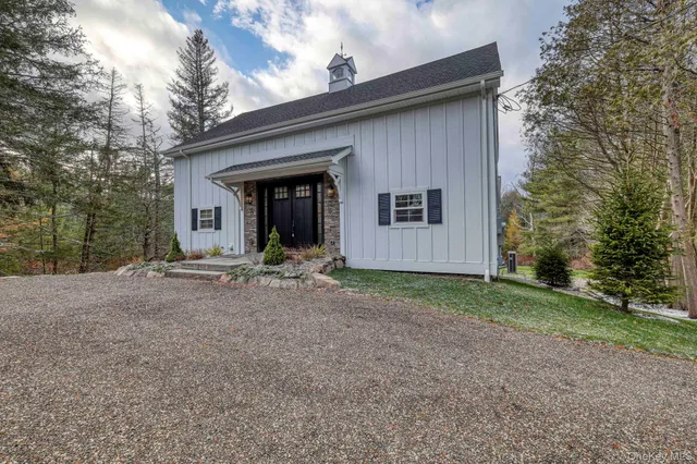 a view of a house with backyard and trees