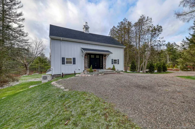 a view of a house with backyard and trees