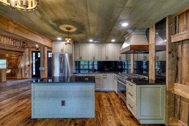a kitchen with stainless steel appliances kitchen island granite countertop a stove and cabinets