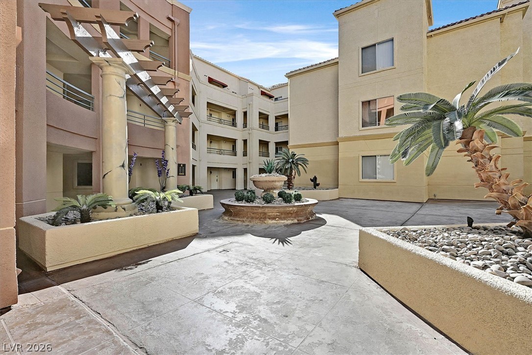 220 East Flamingo Road, Unit 305 Las Vegas, NV 89169 - Photo 16 of 26 A welcoming courtyard with tropical landscaping, an elegant fountain, and well-maintained buildings awaits.