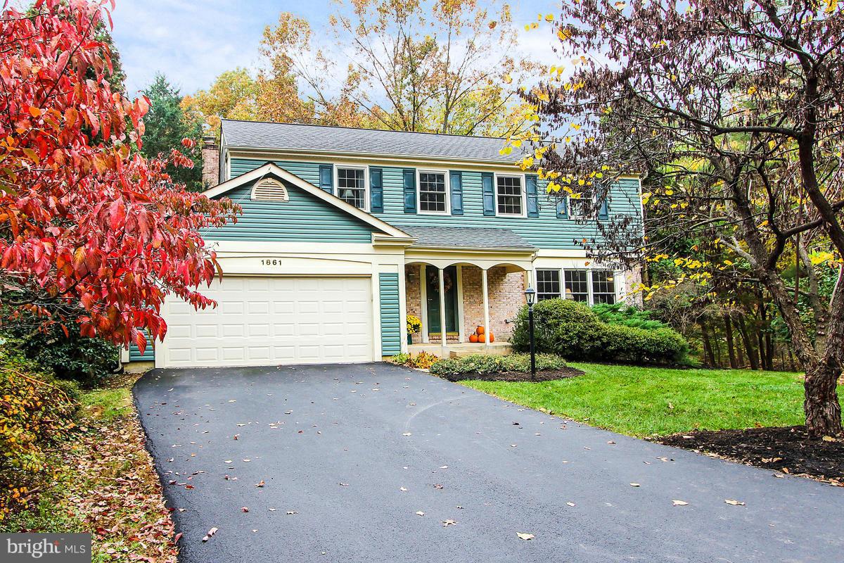 1861 Post Oak Trail Reston, VA 20191 - Photo 1 of 30 a front view of a house with a yard and garage