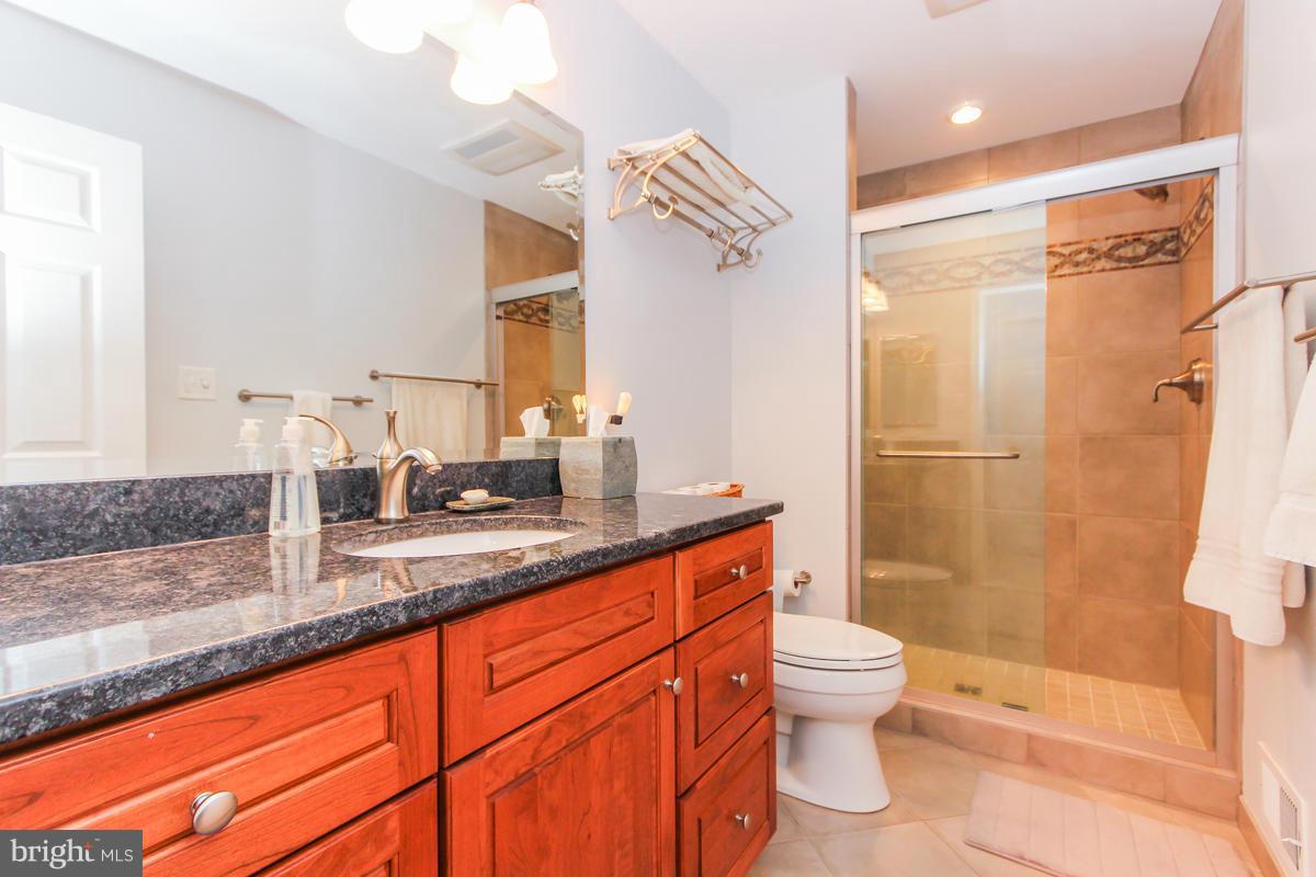 1861 Post Oak Trail Reston, VA 20191 - Photo 20 of 30 a bathroom with a granite countertop sink toilet and shower