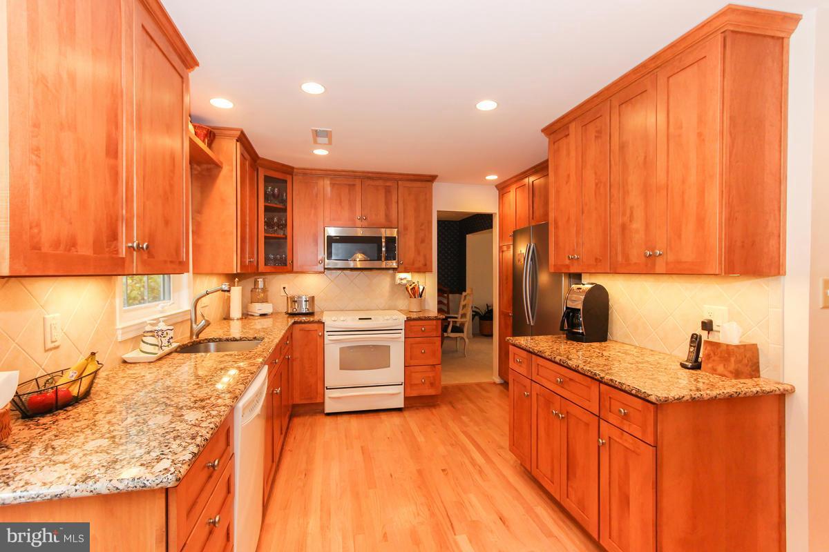 1861 Post Oak Trail Reston, VA 20191 - Photo 3 of 30 a kitchen with stainless steel appliances sink refrigerator and cabinets