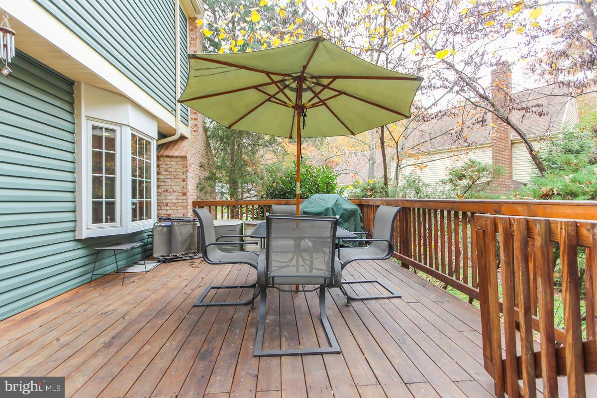1861 Post Oak Trail Reston, VA 20191 - Photo 27 of 30 a view of deck with table and chairs under an umbrella with wooden floor