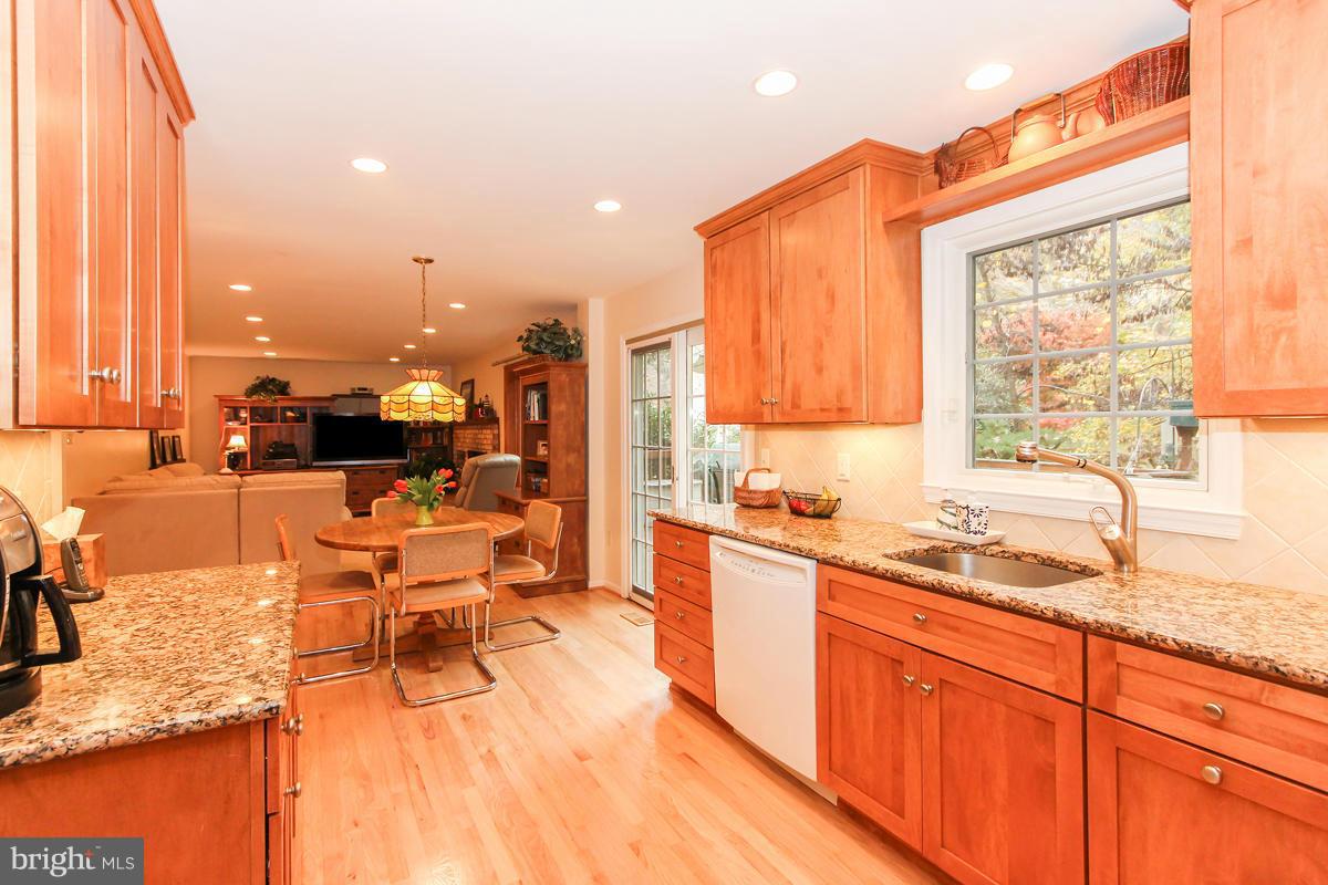 1861 Post Oak Trail Reston, VA 20191 - Photo 4 of 30 a large kitchen with stainless steel appliances kitchen island granite countertop a large window and cabinets