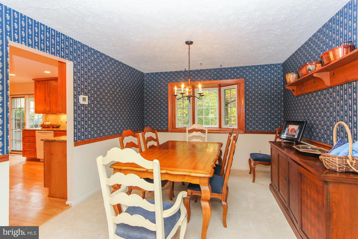 1861 Post Oak Trail Reston, VA 20191 - Photo 10 of 30 a dining room with furniture a chandelier and wooden floor