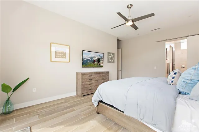 a bedroom with a bed and a painting on the wall