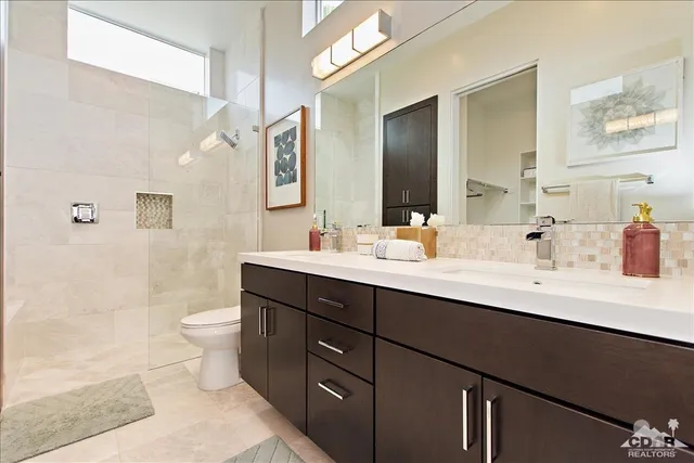 a bathroom with a double vanity sink toilet and shower