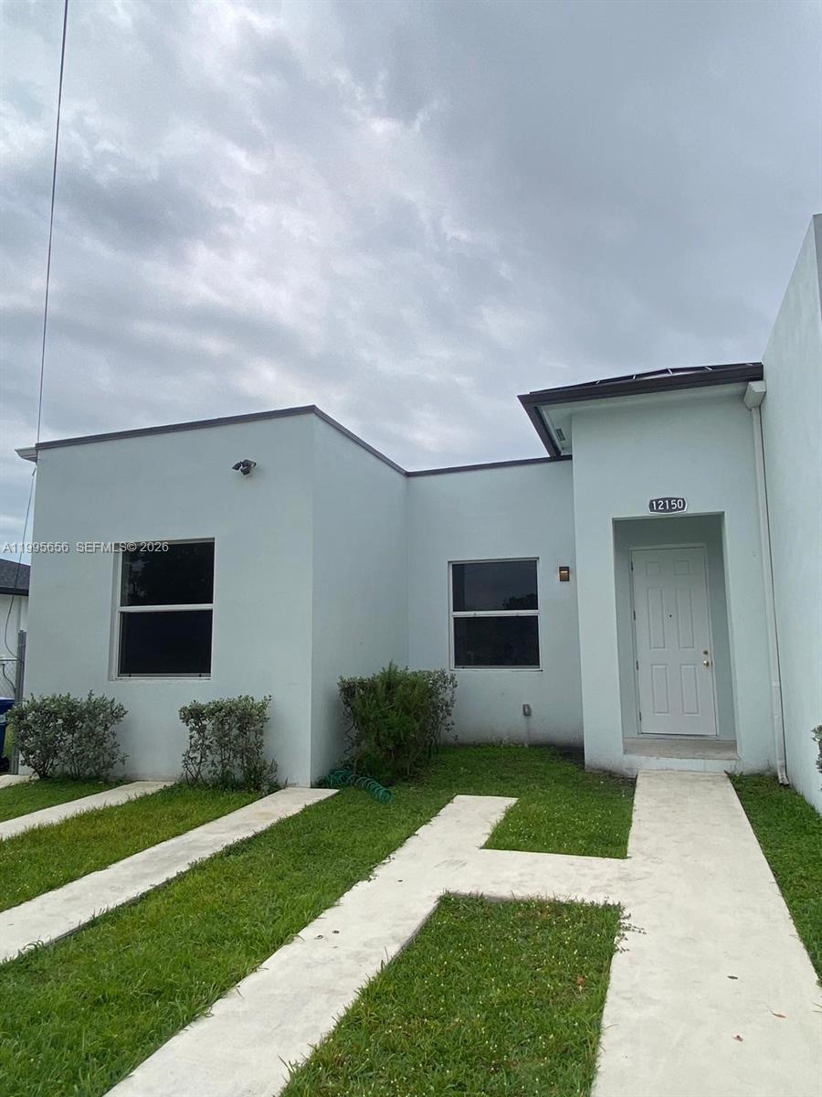 12150 Southwest 213th Street, Unit 12150 Miami, FL 33177 - Photo 1 of 16 a front view of a house with garden