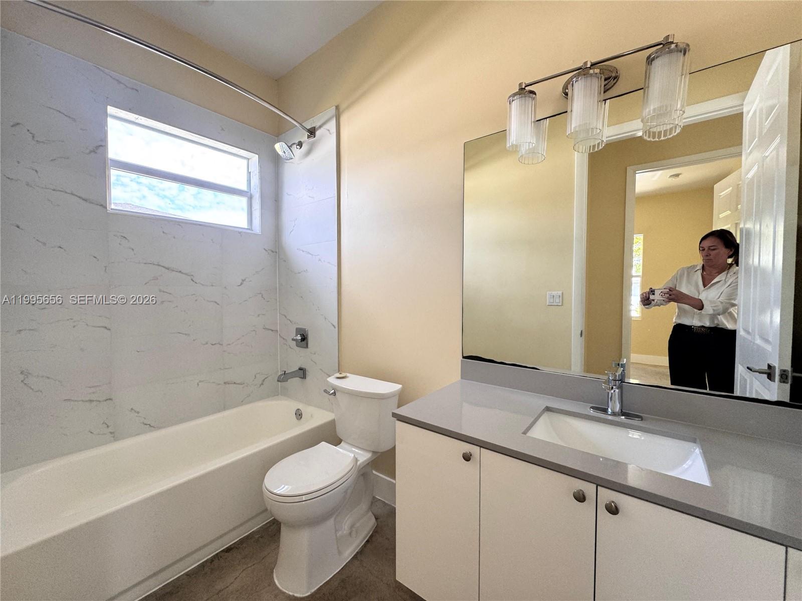 12150 Southwest 213th Street, Unit 12150 Miami, FL 33177 - Photo 11 of 16 a bathroom with a granite countertop sink toilet and shower
