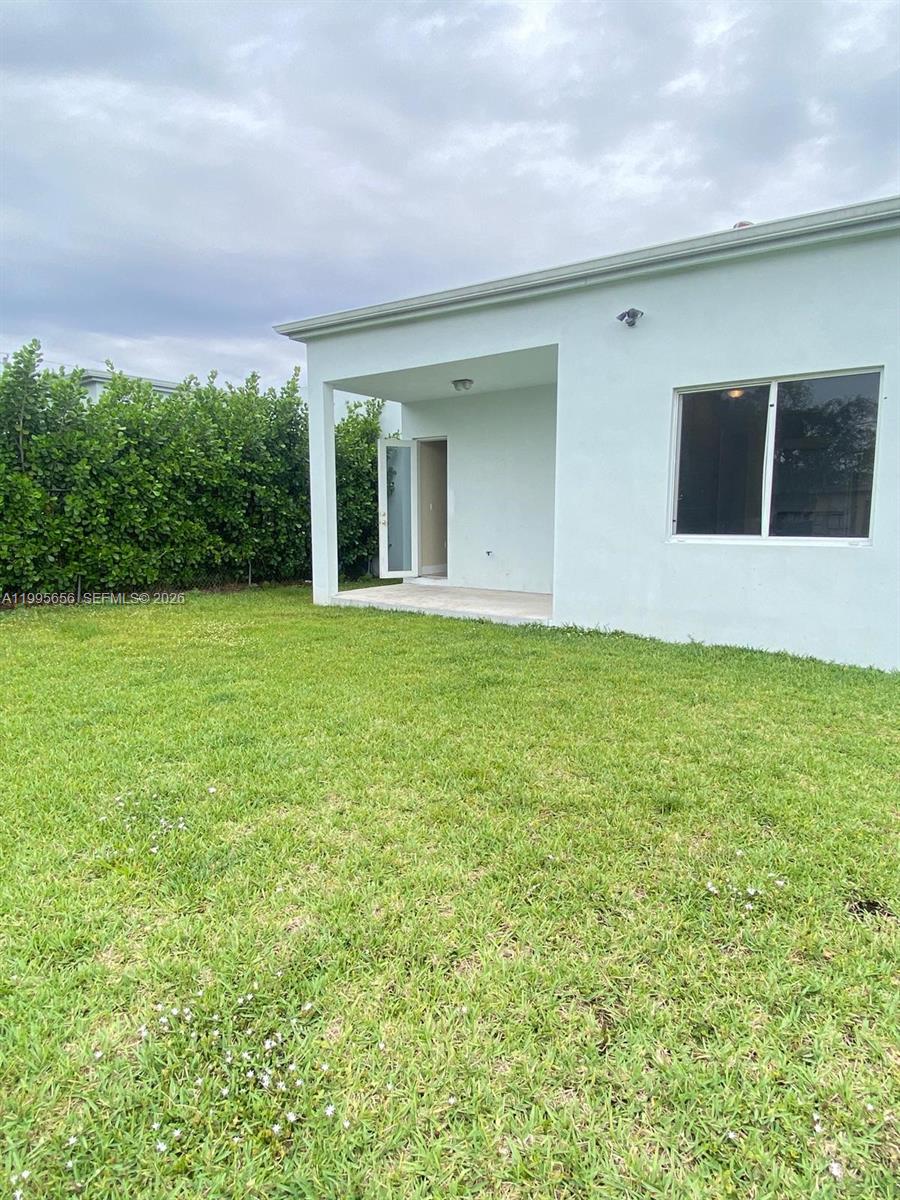 12150 Southwest 213th Street, Unit 12150 Miami, FL 33177 - Photo 2 of 16 a view of a building from a big yard