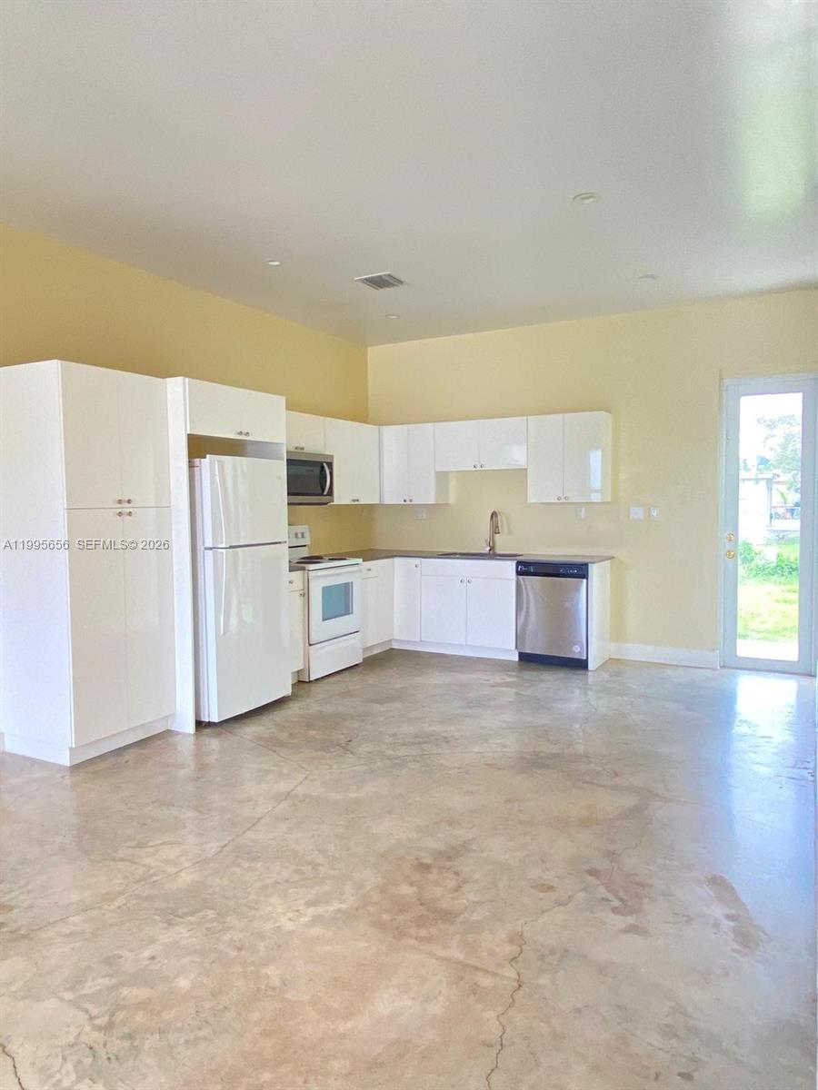 12150 Southwest 213th Street, Unit 12150 Miami, FL 33177 - Photo 4 of 16 a view of kitchen with refrigerator cabinets and outdoor space