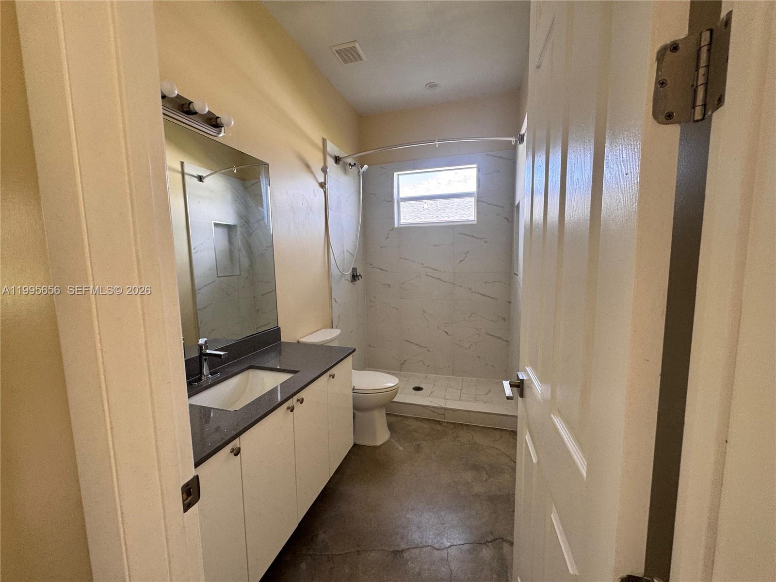 12150 Southwest 213th Street, Unit 12150 Miami, FL 33177 - Photo 8 of 16 a bathroom with a granite countertop sink a toilet and shower