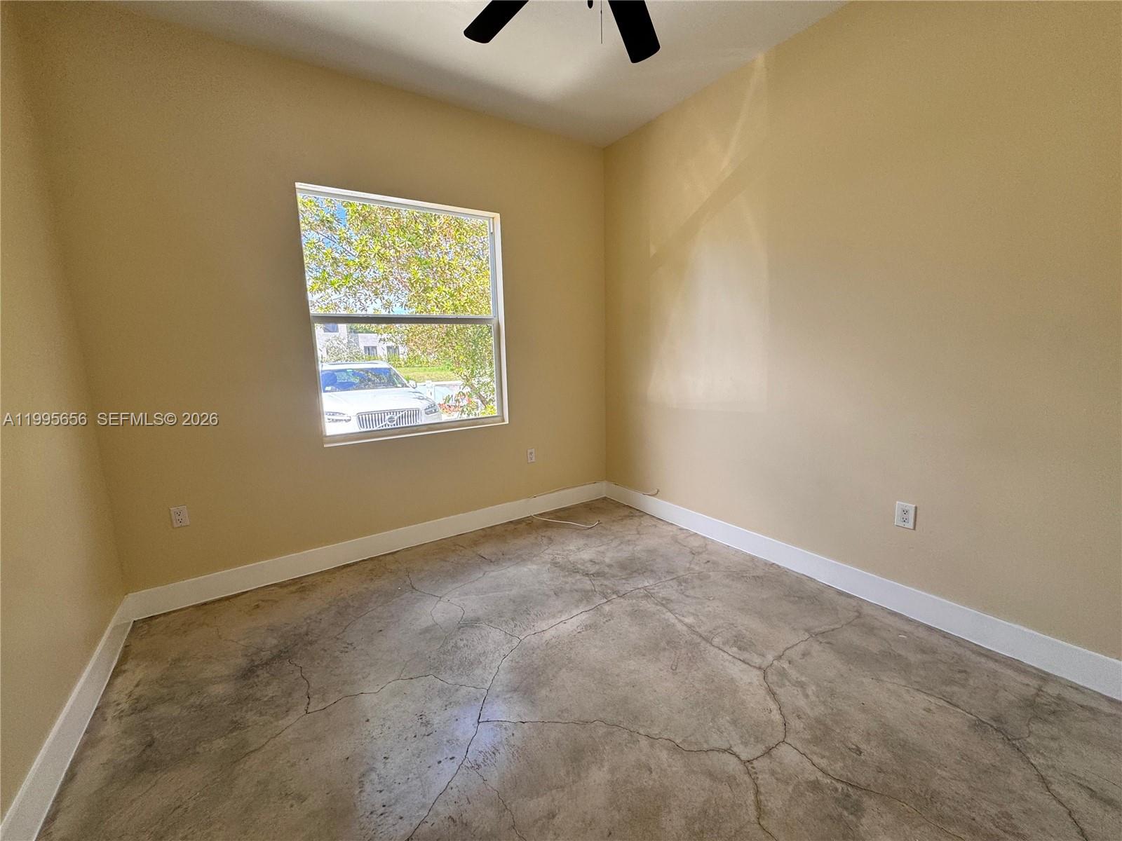 12150 Southwest 213th Street, Unit 12150 Miami, FL 33177 - Photo 9 of 16 an empty room with a window and a ceiling fan