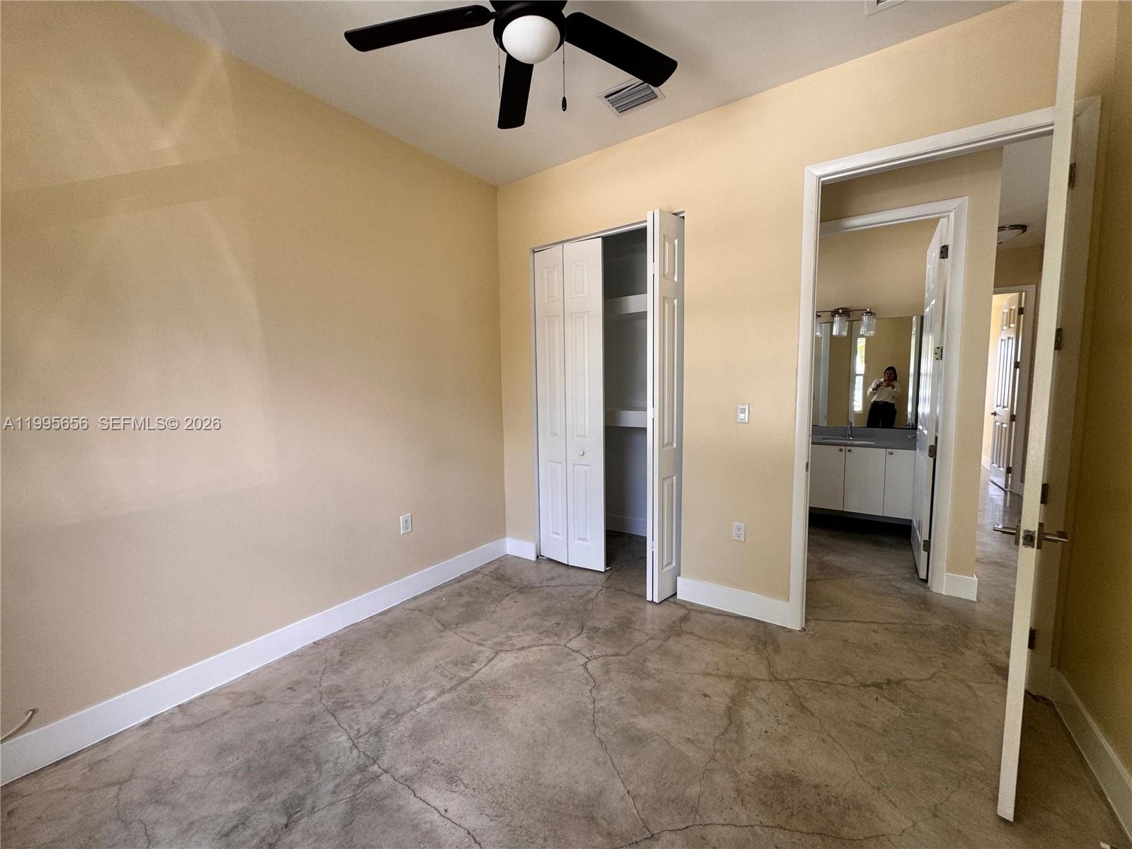12150 Southwest 213th Street, Unit 12150 Miami, FL 33177 - Photo 10 of 16 an empty room with chandelier fan and windows