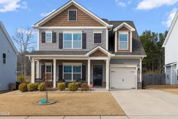 a front view of a house with yard and garage