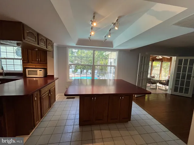 an empty room with windows and chandelier fan