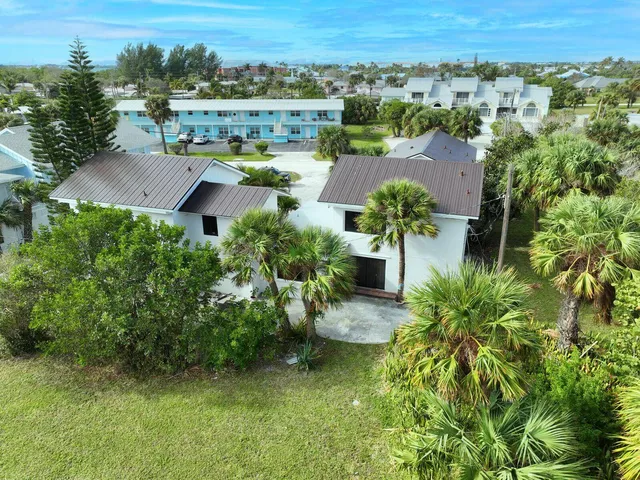 an aerial view of residential houses with outdoor space and trees