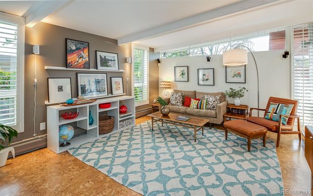 a living room with furniture a rug and a wall painting