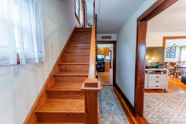 a view of entryway and hall with wooden floor