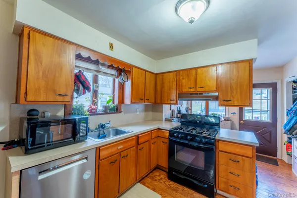 a kitchen with stainless steel appliances granite countertop a stove a sink and a microwave