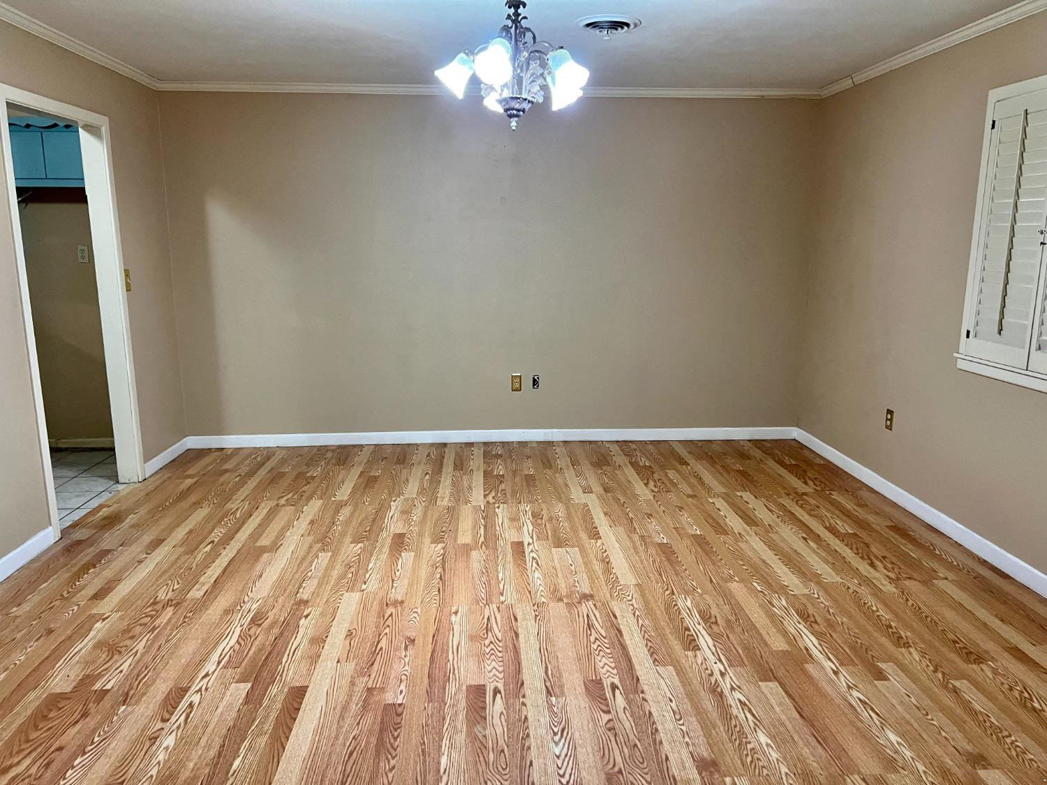 1415 Avenue North Ralls, TX 79357 - Photo 5 of 18 a view of a room with wooden floor and chandelier