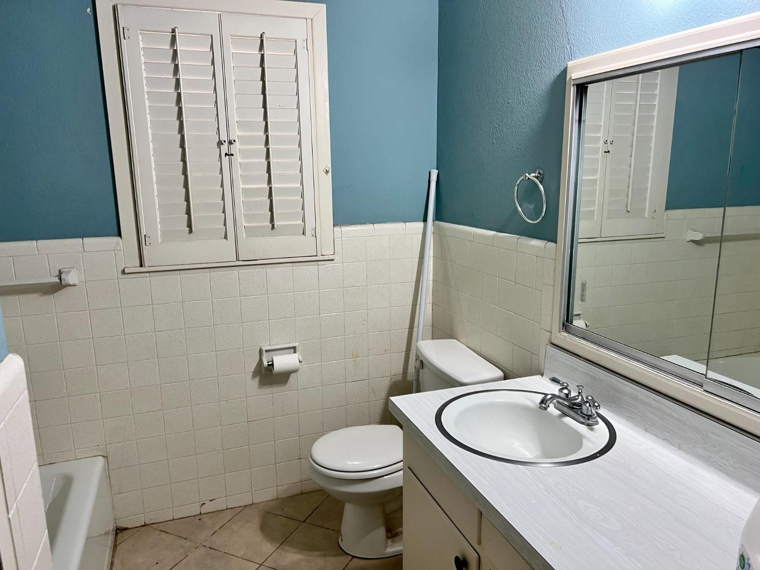 1415 Avenue North Ralls, TX 79357 - Photo 7 of 18 a bathroom with a sink a toilet and mirror