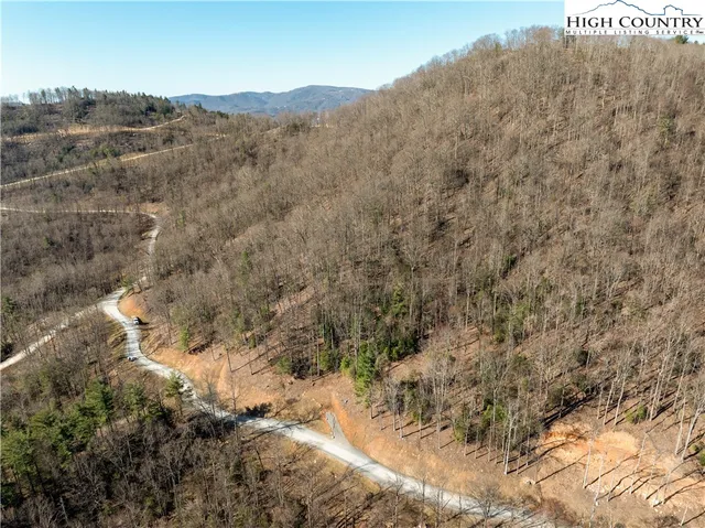 a view of a dry field with mountains in the background