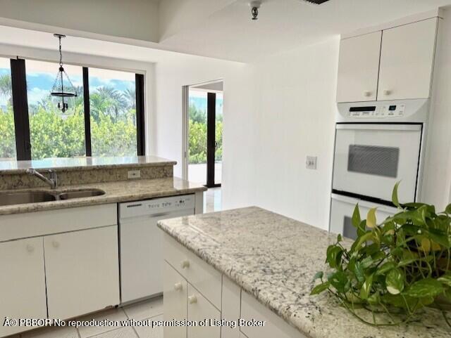 2580 South Ocean Boulevard, Unit 1A1 Palm Beach, FL 33480 - Photo 6 of 24 a kitchen with granite countertop white cabinets and a window