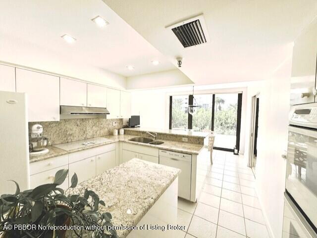 2580 South Ocean Boulevard, Unit 1A1 Palm Beach, FL 33480 - Photo 7 of 24 a large kitchen with kitchen island granite countertop a large window and stainless steel appliances