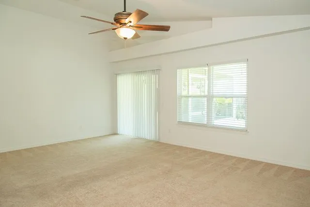 an empty room with a window and a fan