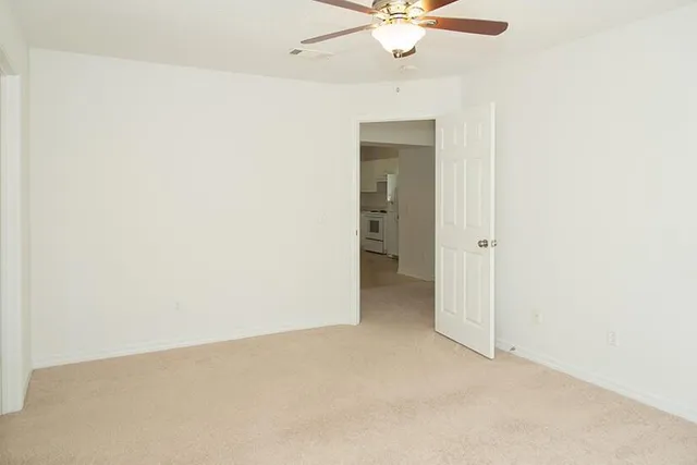 an empty room with a chandelier fan and a ceiling fan